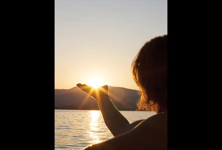 Hand-some sunset: An avid sun chaser holds onto some final rays as the sun sets on a warm July evening on Flathead Lake.