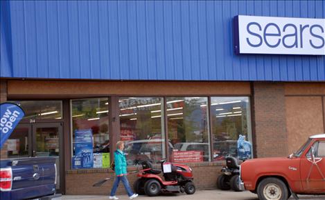 A customer exits Sears with a rake she purchased.