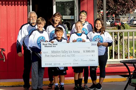 Accepting proceeds of shaved-ice sales for the future ice arena are (front row) Max Violett, Zayne Newman, Corben Carlson and Summer Newman; (back row) Steve Lozar, Carmine Mowbray and Hilary Lozar.