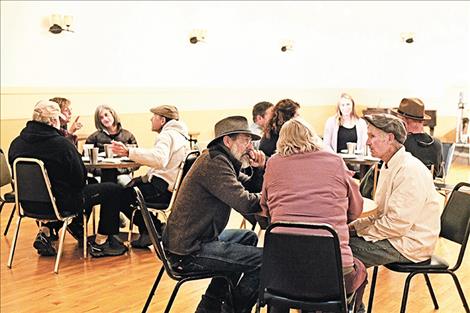 Guests gather and converse while enjoying beer and food.