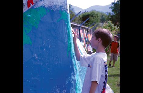 Third-grader Jordan Jurasek locates Montana on a world map created by artists at Linderman. 