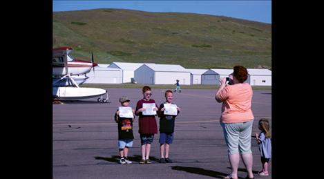 Matthew, Reed and Riley Harbin show mom Heather and little sister Mercy their flight certificates after their Young Eagles flight.