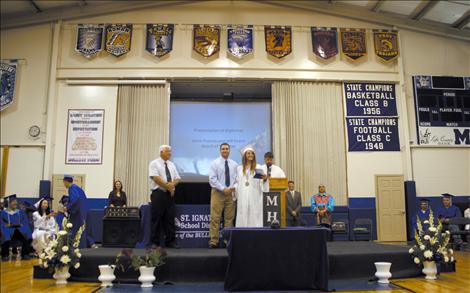 Beaming Salutatorian Sara Nerby recieves her diploma during the graduation ceremony in St. Ignatius High School Saturday.