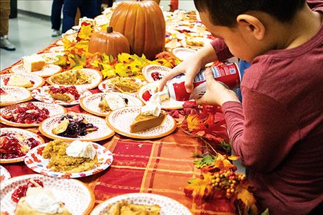 A young volunteer places the finishing touch on a piece of pumpkin pie.