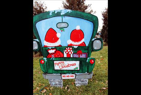 A painted Santa and Mrs. Santa toodle on their way in their pickup.