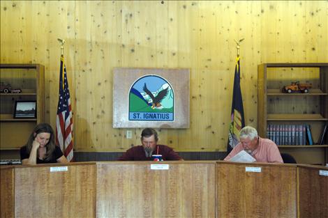 Members of the St. Ignatius City Council, from left, Marine Johnson,  Mayor Charlie Gariepy and Mack McConnell, discuss city business during the June 4 meeting.