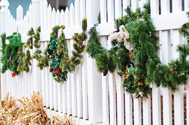 Decked out: Swags of holiday greenery adorn a white picket fence in Polson. 