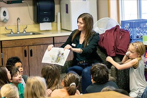 A cluster of Linderman third graders gather around volunteer Megan Ahern as she reads a story about Dr. King.