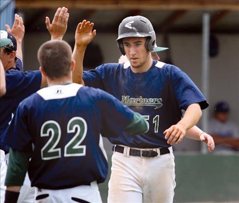 Nick Crawford gets pounded with high fives from teamates after slamming a three-run homer over the fence June 11 against Libby.