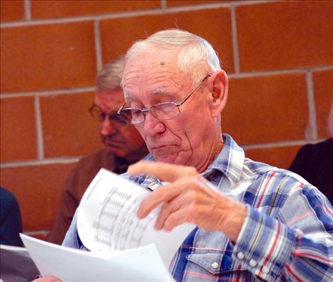 Sonny Dumontier, Cooperative Management Entity of the Flathead Joint Board of Control board member, looks over handouts before the board meeting begins.