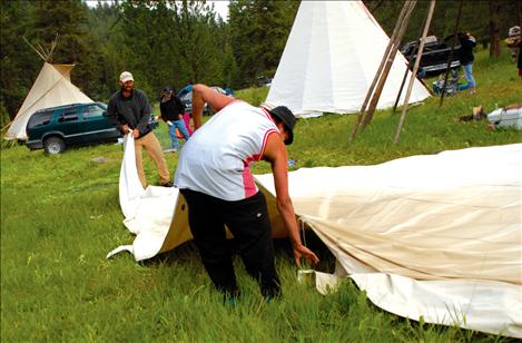 Cosmoe Harlow, foreground, and Chris Stikes fold up tepees as Culture Camp is dismantled. 
