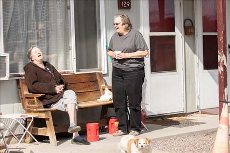 Neighbors  Pam  Robinson  and Laurie  Caswell  enjoy  a laugh  while  maintaining  social  distancing.