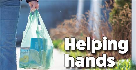 Volunteers carry groceries to people in need during the COVID-19 pandemic. Below: volunteers Leslie Martin and Clay Shoemaker finalize their shopping list.