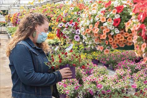 A masked shopper searches for the perfect plant for her garden.
