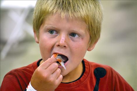 Although 6-year-old Derek Walker of Charlo has never eaten crab before Friday, he quickly learns how to extract the tasty meat.