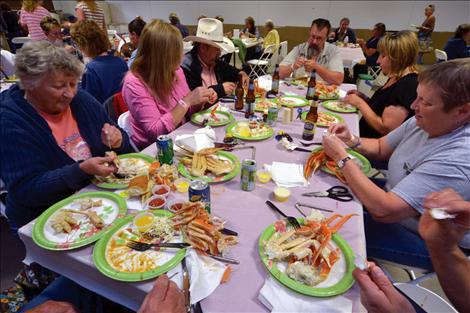 Friends gather around large tables inside the east hall of the Lake County Fairgrounds.