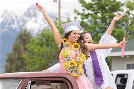 A couple Charlo High School grads  enjoy cheers from a crowd during the  community  send off.