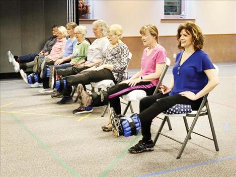 Montana State University Extension Agent Jane Wolery, near right, leads class participants in seated leg lifts at a session of the StrongPeople class last fall in the Choteau Baptist Church fellowship hall. 