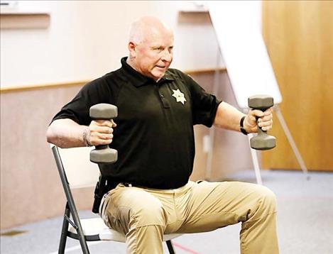 Teton County Sheriff Keith VanSetten, 60, does arm exercises during a session of the StrongPeople class last fall in the Choteau Baptist Church fellowship hall