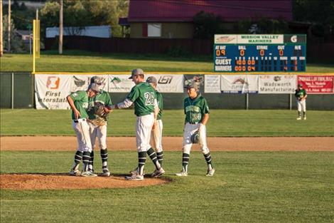 A group of Mariners chat on the mound between innings.