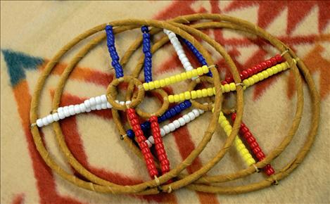 Hoops with beads roll and children can throw an arrow through the larger areas. When their skill improves, they aim for the tiny circle in the middle of the hoop.  Many Native games originally were a way of helping people improve skills, including hand eye coordination, hunting, throwing and quickness before going on a hunting trip.