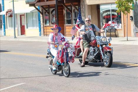 Folks  march down Main Street in Polson  to honor the flag.