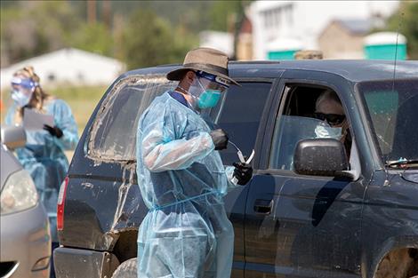 A healthcare worker puts a COVID-19 test into a container.