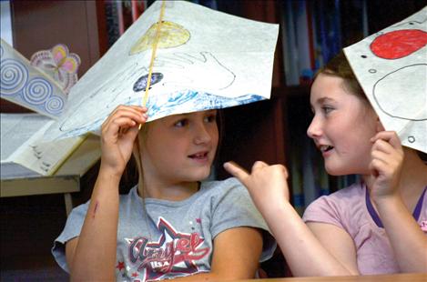 Carla Hahn and Molly Kate Sullivan use their kites as hats.