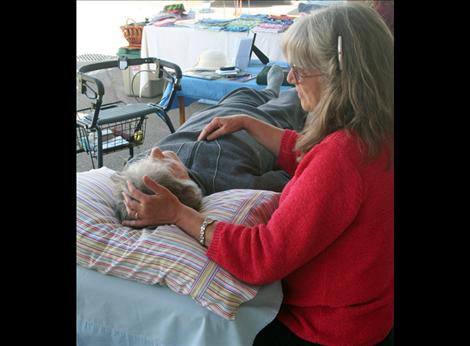 Leta Sasser performs a Reiki treatment at the market.