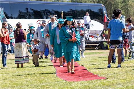 Graduates walk the red carpet.