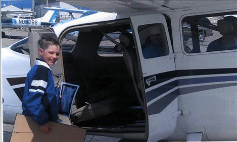 Trey Kelley boards the plane for a ride he won from an aviation art contest. 