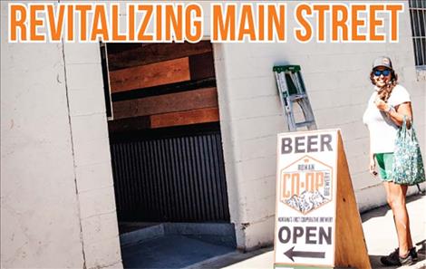 Heidi Fleury sets up signs outside the Ronan CO-OP Brewery as it opened to the public on Sept. 4.