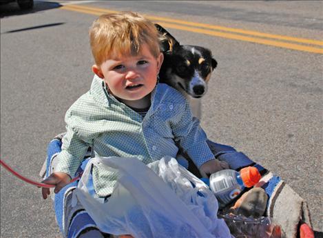 Beau Lytle and his puppy, Brat, ride in style in the family’s little  red wagon down Main Street.