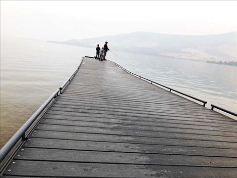 A family fishes from the dock at Big Arm State Park. Fall is a good season to cast near shore for spawning lake trout and whitefish.