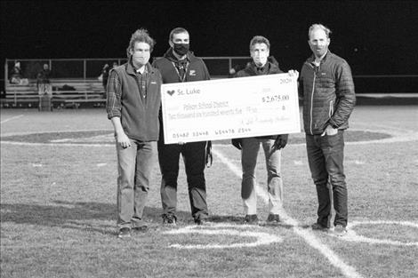 St. Luke Community Healthcare presents a donation to the PHS Athletic Department during halftime. Pictured above: Dr. Isaac Billings, PHS principal Andy Fors, Rob Alfiero, PA-C and  Dr. Tyler Thorson.