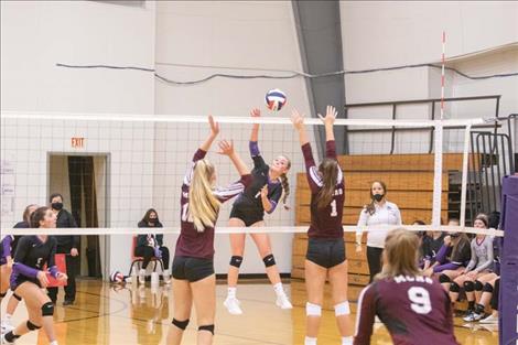 Lady Viking Kassidi Cox swats the ball past Manhattan Christian defenders.