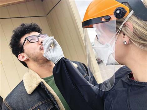 Leona Spittler administers a COVID-19 test to St. Luke employee Trevor Blackburn last week. 