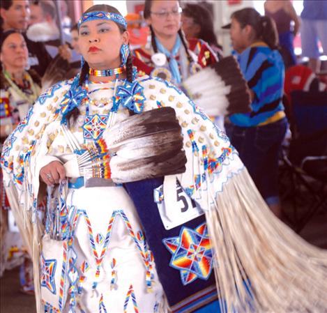 Beads and white buckskin clothe a powwow dancer as she regally enters the dance floor at the Arlee Celebration.
