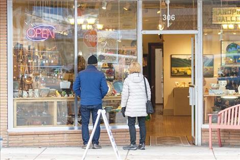 A couple Small Business Saturday shoppers take a  moment to do a little window shopping.