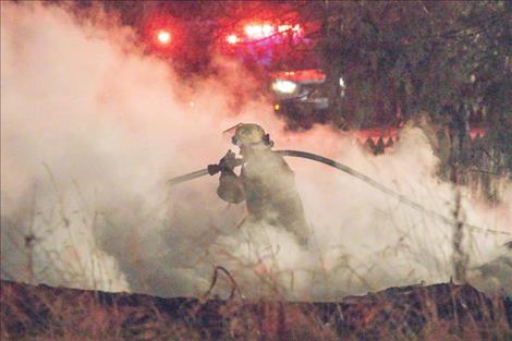 A firefighter knocks down hot spots.