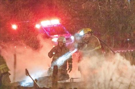 Firefighters conduct mop-up operations.