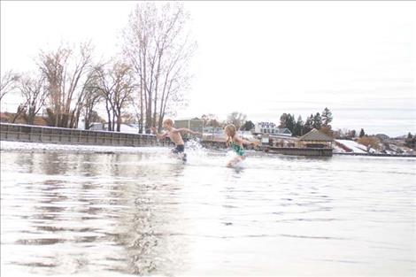 Polson Polar  Plunge participants enjoy the frigid water  on New Years Day. The  event was over quickly  but participants said it  was a good way to  bring in the year.  