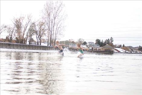 Polson Polar  Plunge participants enjoy the frigid water  on New Years Day. The  event was over quickly  but participants said it  was a good way to  bring in the year.  