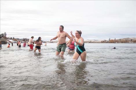 Polson Polar  Plunge participants enjoy the frigid water  on New Years Day. The  event was over quickly  but participants said it  was a good way to  bring in the year.  
