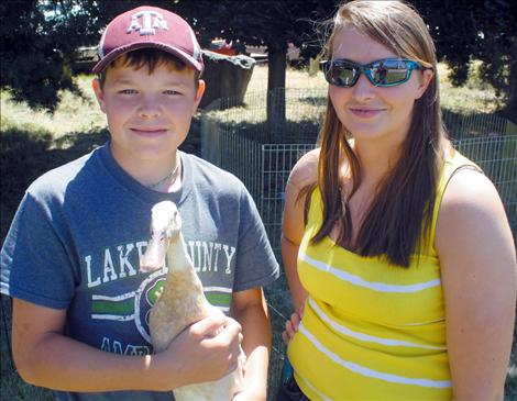 Monica poses with 4-H youth Phillip Vaughan and his project duck.