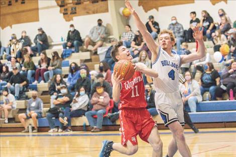 Arlee Warrior Micah Johnson drives to the hoop against Mission Bulldog defender Layne Spidel.