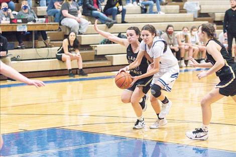 Mission Lady Bulldog Madyson Currie and Lady Pirate Julia Barnard fight for a loose ball.