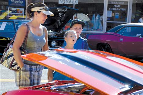 Niki, left, Cason and Colton Graham look at the flames painted on a shiny car at the Cruisen’ by the Bay car show.