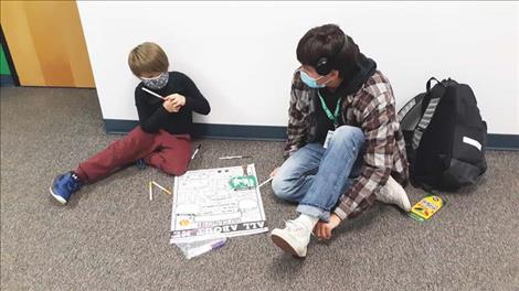 Elijah Tonasket, mentor, with EnZo Jeppesen, mentee, develop a coloring project. 