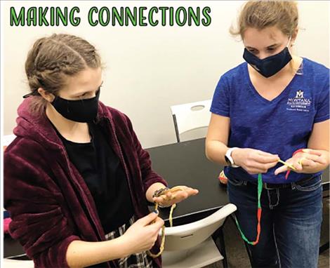 Brookelyn Slonaker, a junior at Polson High School, gets tips on finger weaving from Claudia Hewston, who heads up a mentoring program that serves students in Polson and Ronan.